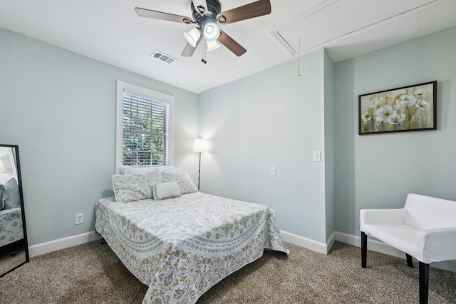 carpeted bedroom featuring visible vents, a ceiling fan, attic access, and baseboards