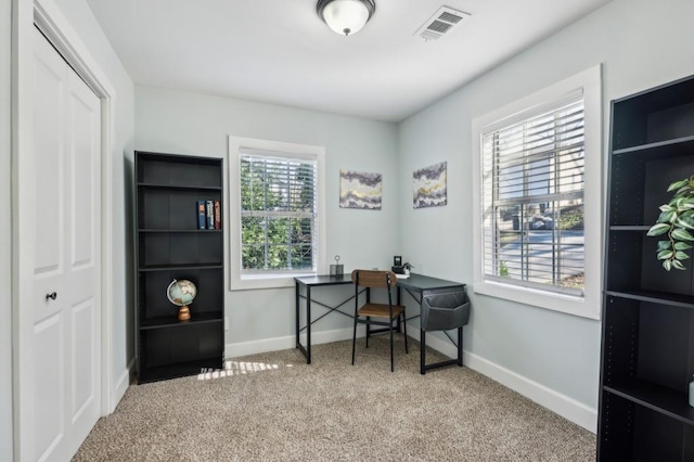 home office with light carpet, visible vents, and baseboards