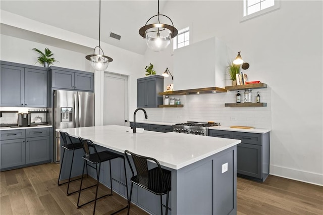 kitchen with visible vents, open shelves, a sink, stove, and wall chimney range hood