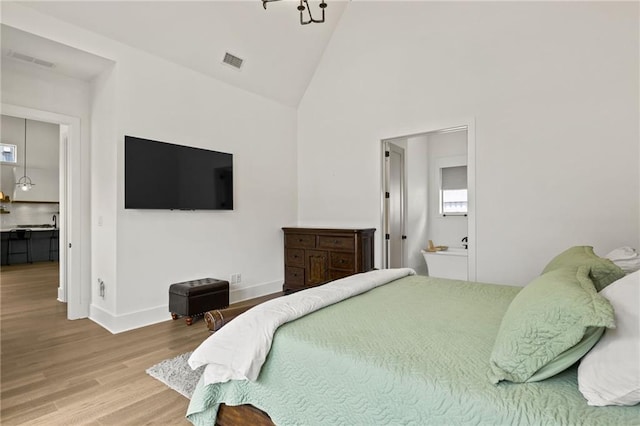 bedroom with visible vents, baseboards, high vaulted ceiling, and wood finished floors