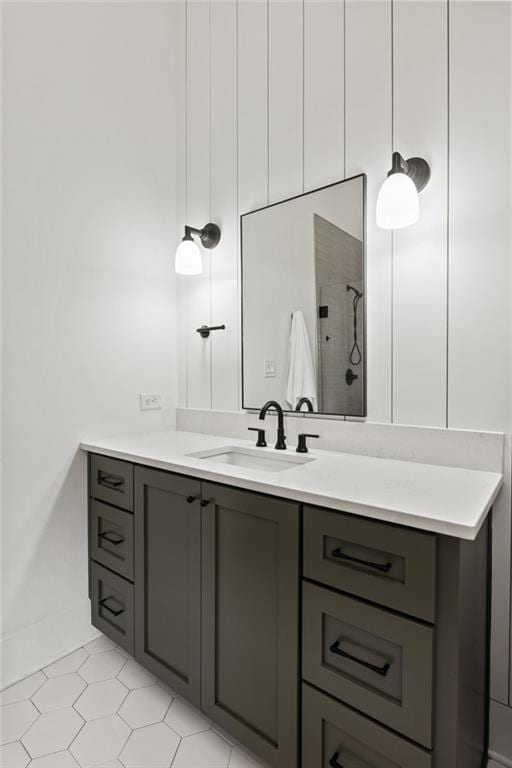 bathroom with tiled shower and vanity