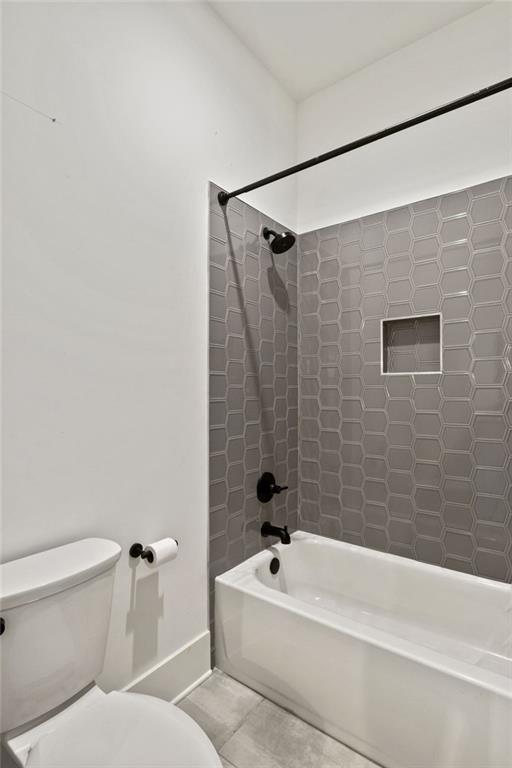 bathroom with tile patterned flooring, toilet, and shower / bathtub combination