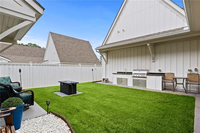 view of yard with fence private yard, exterior kitchen, and a patio