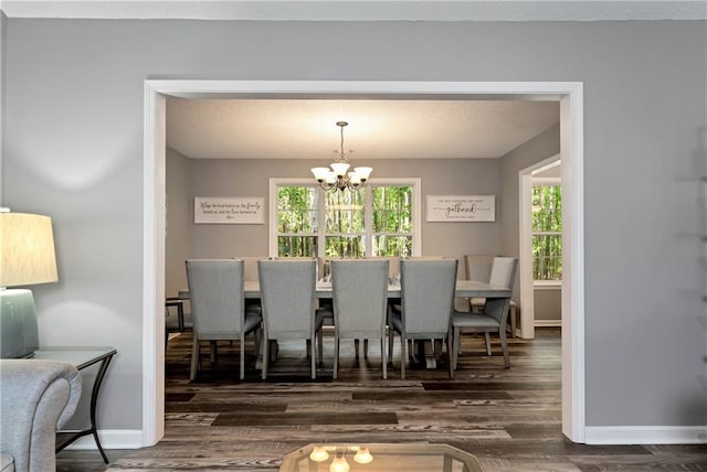 dining room with baseboards, an inviting chandelier, and wood finished floors