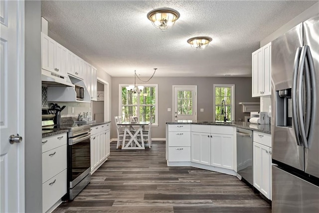 kitchen featuring appliances with stainless steel finishes, a peninsula, white cabinetry, under cabinet range hood, and dark wood-style floors