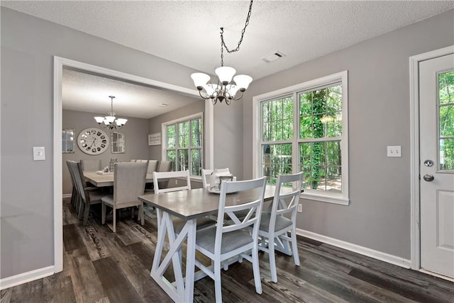 dining space featuring a textured ceiling, dark wood-style flooring, and a chandelier