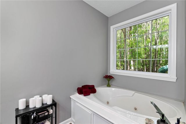 bathroom with a whirlpool tub and a textured ceiling