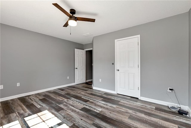 unfurnished bedroom featuring baseboards, a ceiling fan, and dark wood finished floors