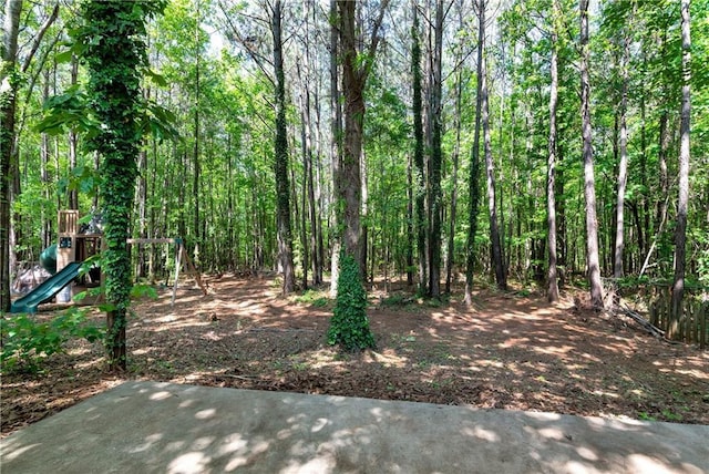 view of yard featuring a view of trees and a playground