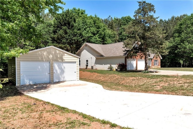 view of side of home with an outdoor structure, a garage, and a lawn