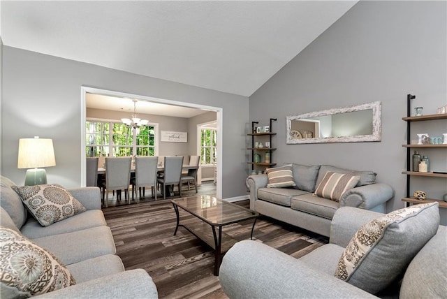 living area with baseboards, lofted ceiling, wood finished floors, and a notable chandelier