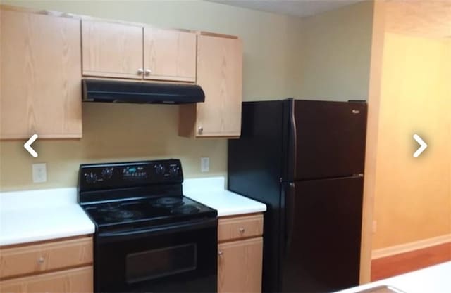 kitchen with light brown cabinets and black appliances