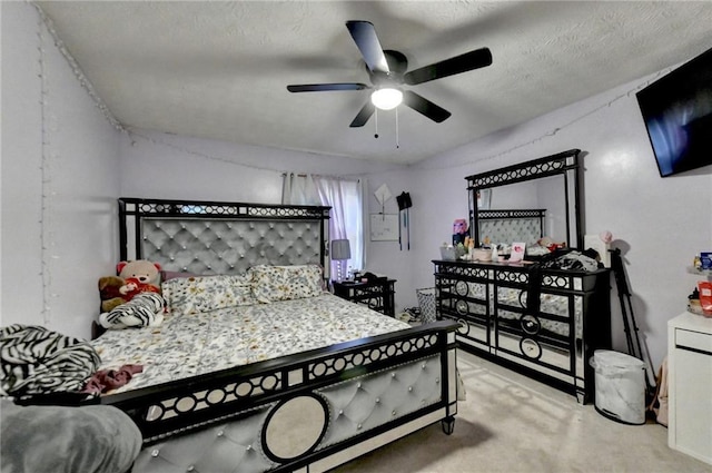 bedroom featuring light colored carpet, ceiling fan, and a textured ceiling