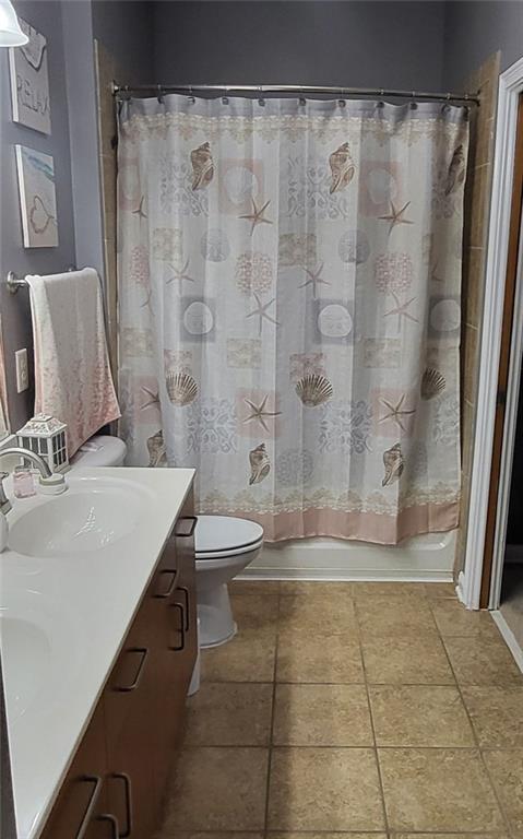 full bathroom with vanity, shower / bath combo with shower curtain, toilet, and tile patterned flooring