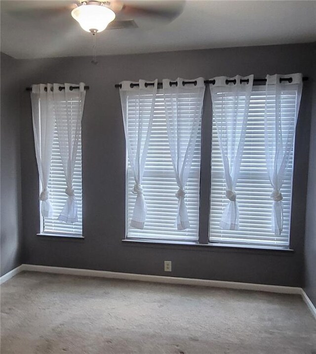 carpeted spare room with ceiling fan