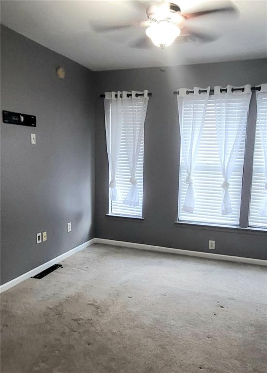 spare room featuring carpet and ceiling fan