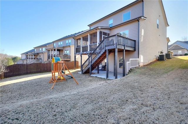 back of house featuring a wooden deck, a sunroom, central AC, and a patio