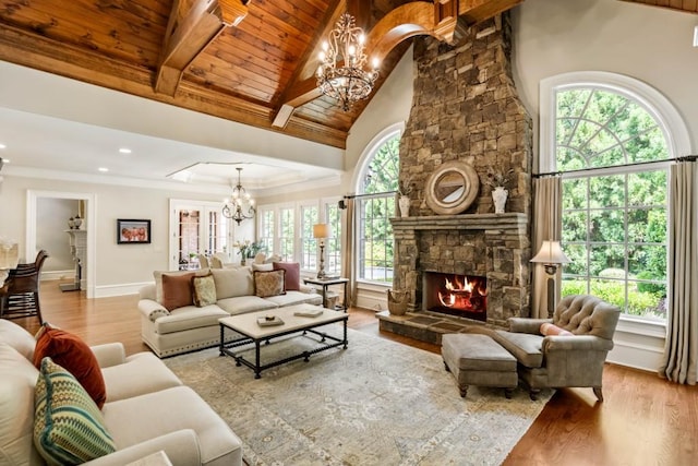 living room featuring high vaulted ceiling, beamed ceiling, wooden ceiling, a fireplace, and light hardwood / wood-style floors