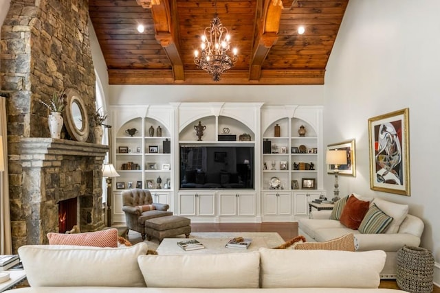 living room with lofted ceiling with beams, built in features, wooden ceiling, a chandelier, and a stone fireplace