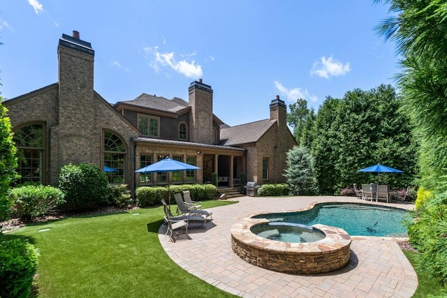 view of pool featuring a lawn, an in ground hot tub, and a patio