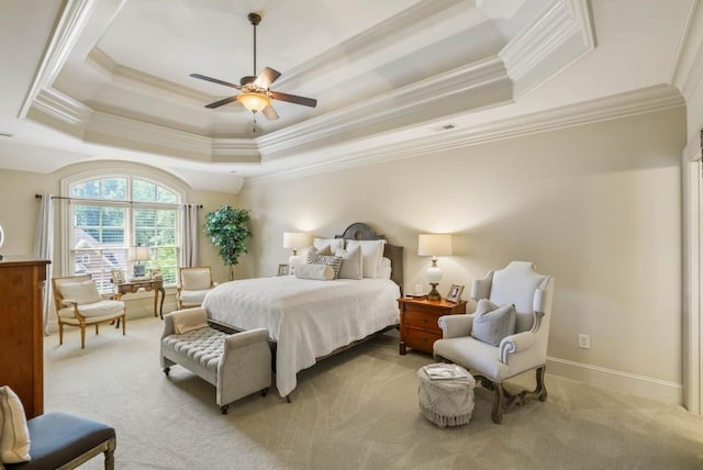 bedroom featuring ornamental molding, a tray ceiling, ceiling fan, and light colored carpet