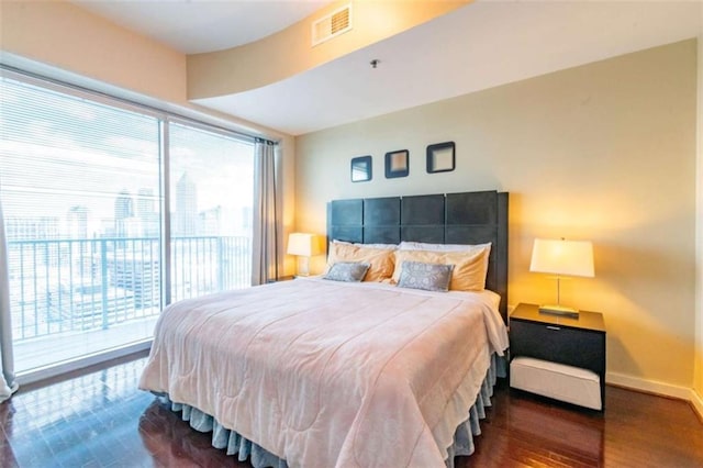 bedroom featuring dark hardwood / wood-style flooring and access to exterior