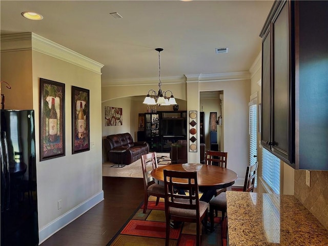 520 Harmony Way, Locust Grove, GA 30248 - dining room with a chandelier, dark wood-style floors, ornamental molding, baseboards, and arched walkways
