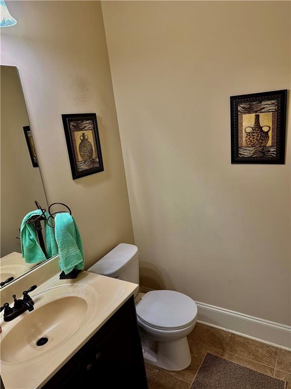 520 Harmony Way, Locust Grove, GA 30248 - bathroom featuring toilet, vanity, baseboards, and tile patterned flooring