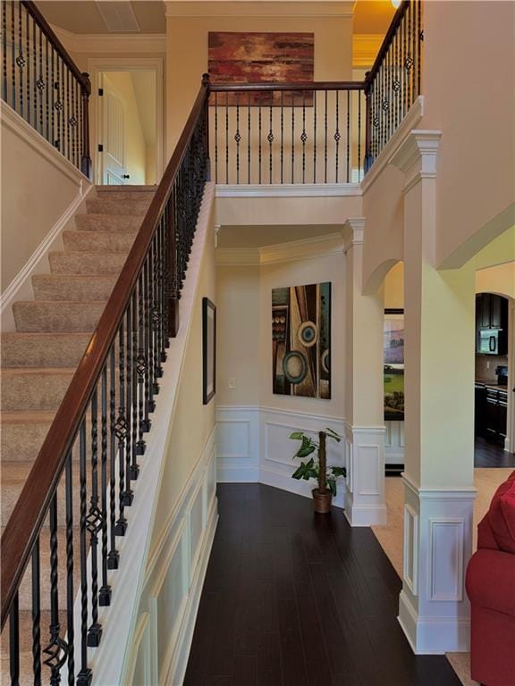 520 Harmony Way, Locust Grove, GA 30248 - staircase featuring a high ceiling, ornamental molding, wood finished floors, a wainscoted wall, and a decorative wall