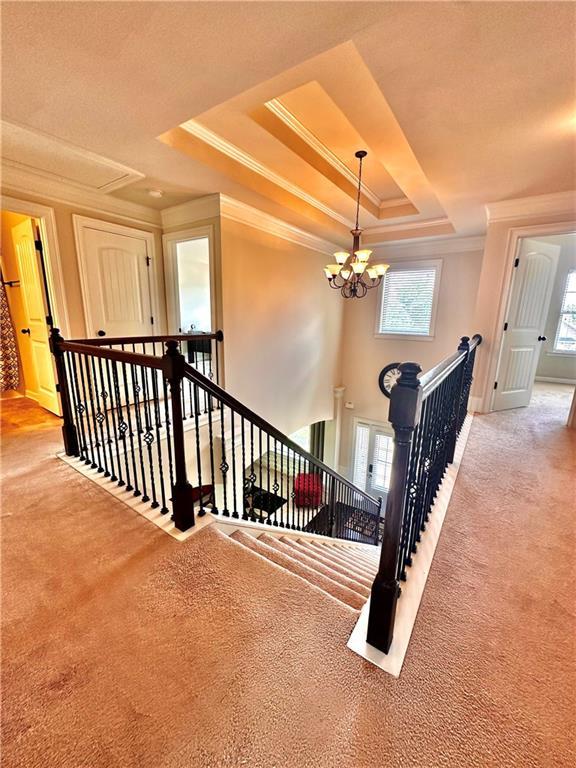 520 Harmony Way, Locust Grove, GA 30248 - stairs with crown molding, carpet floors, a raised ceiling, and a chandelier
