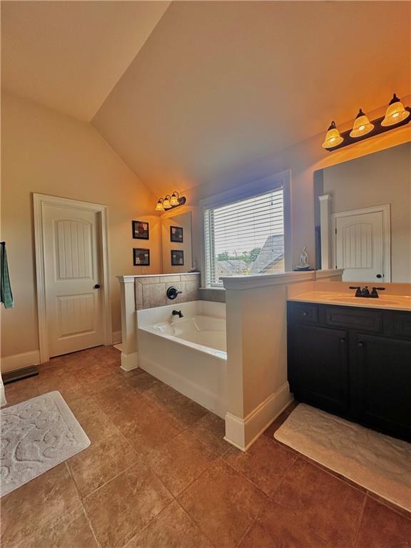 520 Harmony Way, Locust Grove, GA 30248 - full bath featuring a bath, vanity, lofted ceiling, baseboards, and tile patterned flooring