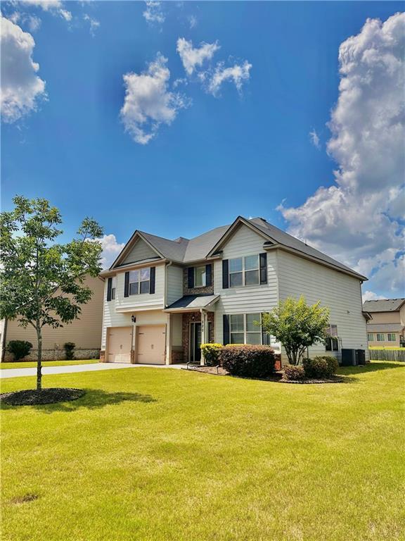 520 Harmony Way, Locust Grove, GA 30248 - view of front of home with a garage, concrete driveway, a front lawn, and central air condition unit