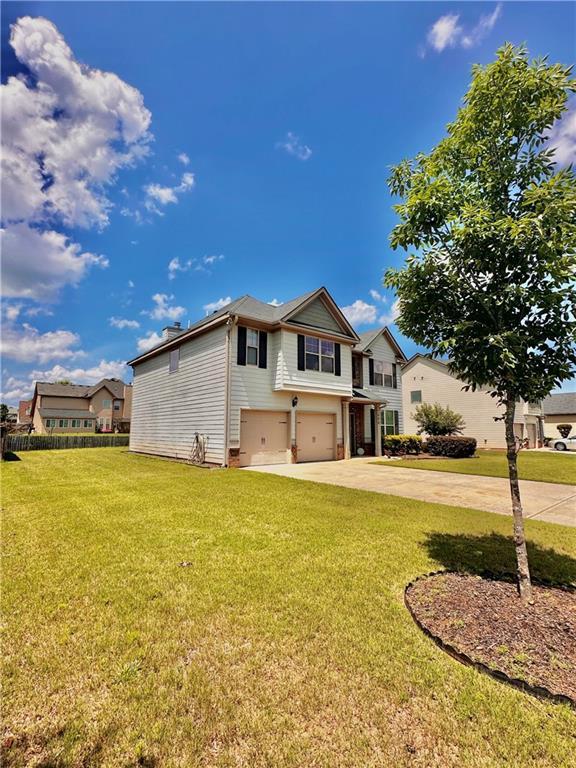 520 Harmony Way, Locust Grove, GA 30248 - traditional home with an attached garage, driveway, and a front yard