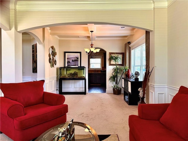 520 Harmony Way, Locust Grove, GA 30248 - carpeted living area with arched walkways, crown molding, a chandelier, a decorative wall, and wainscoting