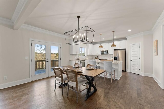 dining space featuring an inviting chandelier, dark hardwood / wood-style flooring, french doors, crown molding, and sink