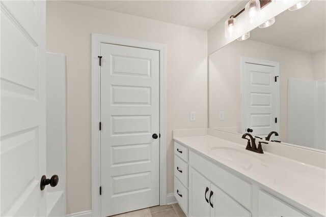 bathroom with walk in shower, tile patterned floors, and vanity