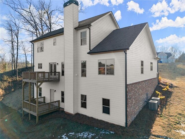 rear view of property featuring central AC unit, a deck, and a balcony