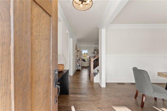 entrance foyer featuring ornamental molding and dark hardwood / wood-style flooring