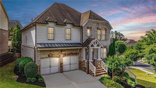11760 Stratham Dr, Alpharetta, GA 30009 - view of front of property with a garage, driveway, a standing seam roof, a yard, and stone siding