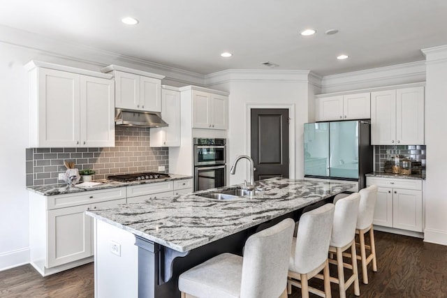 11760 Stratham Dr, Alpharetta, GA 30009 - kitchen with stainless steel appliances, decorative backsplash, dark wood finished floors, a breakfast bar, and white cabinets