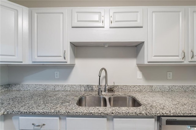 1406 Windy Ridge Ct SE, Conyers, GA 30013 - kitchen with a sink, white cabinetry, dishwashing machine, and light stone countertops