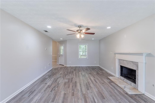 1406 Windy Ridge Ct SE, Conyers, GA 30013 - unfurnished living room featuring light wood-style flooring, ceiling fan, a premium fireplace, baseboards, and recessed lighting