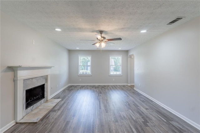 1406 Windy Ridge Ct SE, Conyers, GA 30013 - unfurnished living room with ceiling fan, dark wood finished floors, a tiled fireplace, a textured ceiling, and baseboards