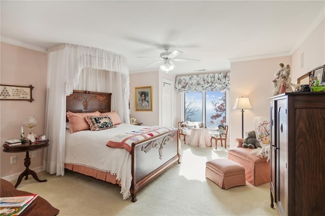 bedroom with baseboards, ornamental molding, a ceiling fan, and light colored carpet