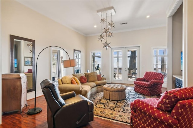 living area featuring french doors, wood finished floors, visible vents, and crown molding