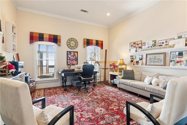 living area with visible vents and crown molding