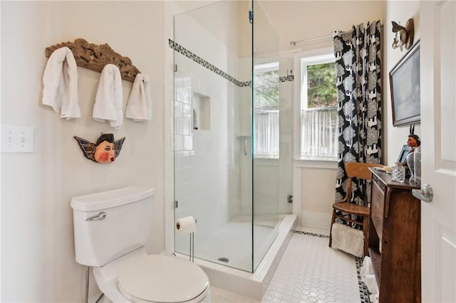 full bathroom featuring toilet, a stall shower, and tile patterned flooring