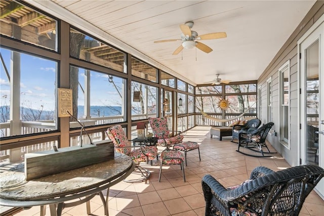 sunroom with a mountain view and a ceiling fan