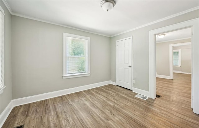 empty room with crown molding and wood-type flooring