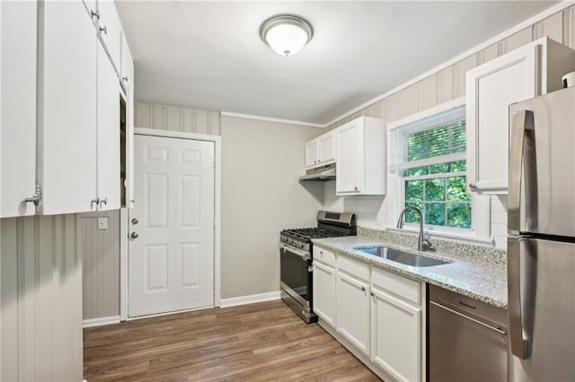 kitchen with sink, white cabinetry, hardwood / wood-style floors, and stainless steel appliances